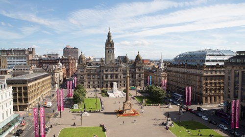 A picture of George Square and Glasgow City Chambers taken from the opposite side of the square.