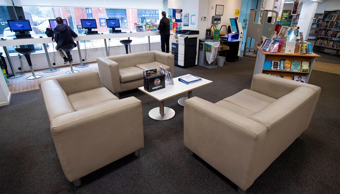 A view of the sofa area in Anniesland Library. There are three sofas facing each other and in the background you can see the PC's at the window and a stand alone bookshelf.