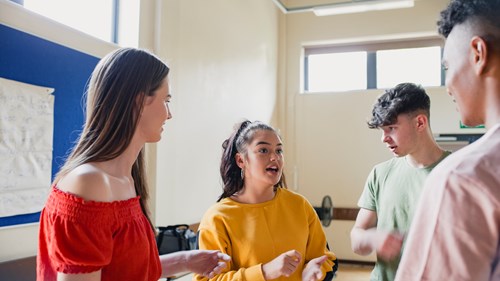 Group young people in brightly coloured clothing having an animated discussion