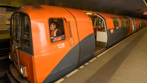 orange subway carriage driven by a person